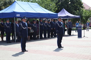 Policjanci w umundurowaniu wyjściowym na placu Tadeusza Kościuszki podczas uroczystości z pocztem sztandarowym i zaproszonymi gośćmi.