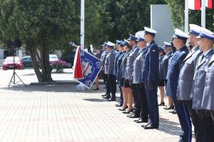 Policjanci w umundurowaniu wyjściowym na placu Tadeusza Kościuszki podczas uroczystości z pocztem sztandarowym i zaproszonymi gośćmi.