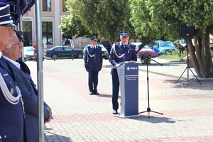 Policjanci w umundurowaniu wyjściowym na placu Tadeusza Kościuszki podczas uroczystości z pocztem sztandarowym i zaproszonymi gośćmi.