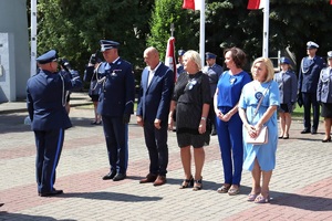 Policjanci w umundurowaniu wyjściowym na placu Tadeusza Kościuszki podczas uroczystości z pocztem sztandarowym i zaproszonymi gośćmi.