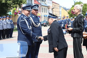 Policjanci w umundurowaniu wyjściowym na placu Tadeusza Kościuszki podczas uroczystości z pocztem sztandarowym i zaproszonymi gośćmi.