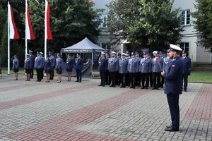 Policjanci w umundurowaniu wyjściowym na placu Tadeusza Kościuszki podczas uroczystości z pocztem sztandarowym i zaproszonymi gośćmi.