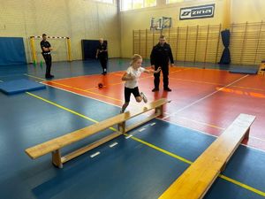 Uczniowie z policjantami na sali gimnastycznej podczas turnieju.