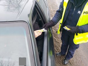 Policjantka rozdaje kierującym serduszka. Policjant z policjantką obok radiowozu.