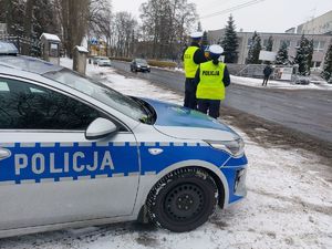 Policjantka rozdaje kierującym serduszka. Policjant z policjantką obok radiowozu.