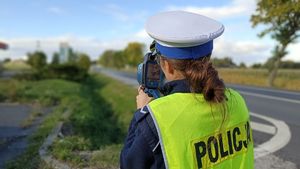 Policjantka z radarem mierzy prędkość.