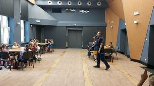 Policjantka z dziećmi w sali domu kultury.