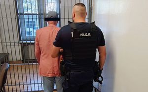 Policjanci z zatrzymanym obok radiowozu.