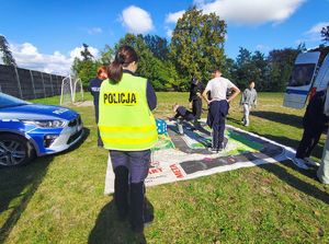 Policjanci, radiowóz uczestnicy wydarzeń plenerowych.