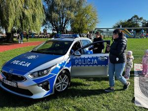 Policjanci, radiowóz uczestnicy wydarzeń plenerowych.