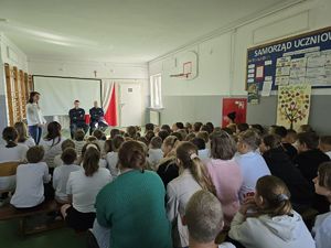 Policjanci z dziećmi w sali.