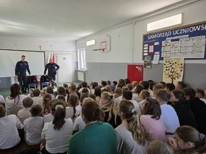 Policjanci z dziećmi w sali.