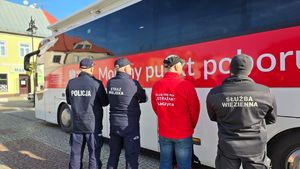 Funkcjonariusze obok ambulansu.