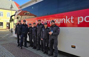 Funkcjonariusze obok ambulansu.