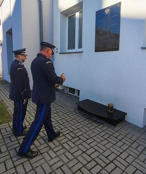 Policjanci oddają hołd pod pomnikiem i tablicą pamiątkową.