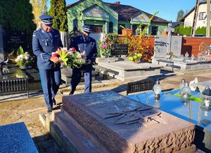 Policjanci oddają hołd pod pomnikiem i tablicą pamiątkową.