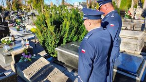 Policjanci oddają hołd pod pomnikiem i tablicą pamiątkową.