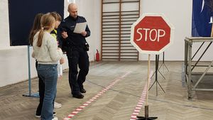 Policjanci i uczniowie na wydarzeniu z odblaskami.