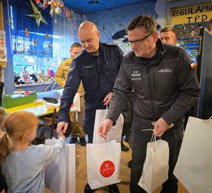 Funkcjonariusze w mundurach. Paczki dla dzieci.