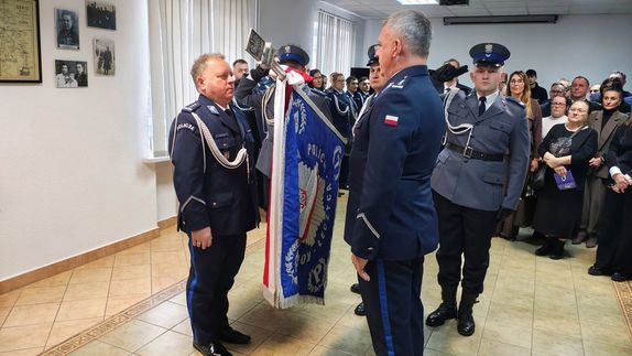 Policjanci obok sztandaru jednostki.