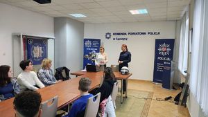 Policjanci w sali odpraw z uczniami.