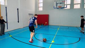 Policjanci i uczestnicy turnieju na sali gimnastycznej w szkole imienia Jadwigi Grodzkiej.