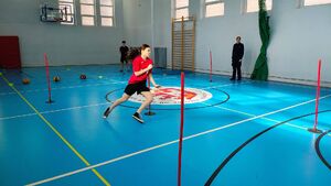 Policjanci i uczestnicy turnieju na sali gimnastycznej w szkole imienia Jadwigi Grodzkiej.