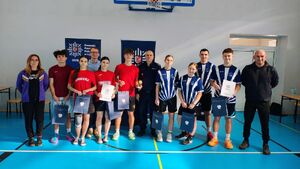 Policjanci i uczestnicy turnieju na sali gimnastycznej w szkole imienia Jadwigi Grodzkiej.