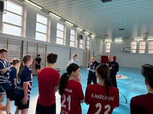 Policjanci i uczestnicy turnieju na sali gimnastycznej w szkole imienia Jadwigi Grodzkiej.