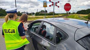 Policjantka i przedstawicielka kolei na przejazdach kolejowych, w tle radiowóz.