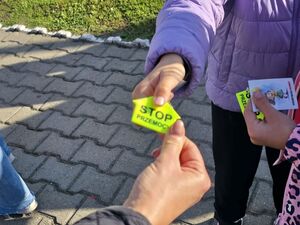 Wręczane elementów odblaskowych uczestnikom marszu.