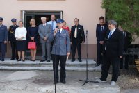 Policjant podczas przemówienia z tyłu zaproszeni goście.