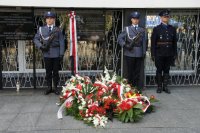 Policjanci przed tablicą pamiątkową.