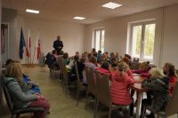 Dzieci z policjantem w sali odpraw.