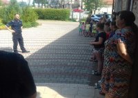 umundurowany policjant podczas rozmowy z dziećmi w Siedlcu.