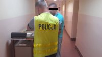 policjant podczas czynności daktyloskopii podejrzanego.